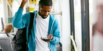 Man looking at a cell phone while on mass transit